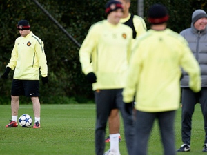 Manchester United's Wayne Rooney, left, during a training session with teammates and manager Alex Ferguson, right, stands by at Carrington training ground the day before their Champion's League soccer match against Bursaspor, Manchester, England, Tuesday Oct. 19, 2010. Manchester United manager Alex Ferguson confirmed Tuesday that Wayne Rooney wants to leave the Premier League club. "We have had a discussion about the whole situation. The player says he is adamant he wants to leave," Ferguson said. (AP Photo/Jon Super)  