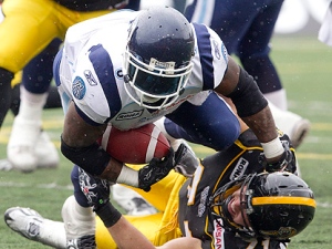 Hamilton Tiger-Cats defensive end Garrett McIntyre (bottom) hauls down Toronto Argonauts running back Cory Boyd (3) during first half CFL Eastern Conference Semi-Final action in Hamilton, Ontario on Sunday November 14, 2010. (THE CANADIAN PRESS/Frank Gunn)