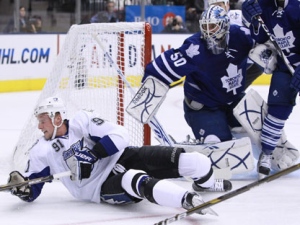 Tampa Bay Lightning's Steven Stamkos, left, falls in front of Toronto Maple Leafs' goaltender Jonas Gustavsson during first period NHL hockey action in Toronto Tuesday, November 30, 2010. (THE CANADIAN PRESS/Darren Calabrese)