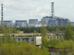 In this May 10, 2007 file photo a general view of empty houses in the town of Pripyat and the closed Chernobyl nuclear power plant in the background. Next year, Ukraine will open up the contaminated zone around the Chernobyl reactor to visitors who wish to learn more about the nuclear tragedy that occurred there 24 years ago, the Emergency Situations Ministry said Monday Dec 13 2010. (AP Photo/Efrem Lukatsky, file)