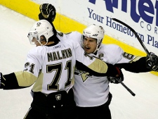 Pittsburgh Penguins' Sidney Crosby, right, celebrates with teammates Evgeni Malkin (71) and Pascal Dupuis (9), of Russia, after scoring a goal against the Washington Capitals during the first period of an NHL hockey game Thursday, Dec. 23, 2010, in Washington. The Penguins won 3-2 in a shootout. (AP Photo/Luis M. Alvarez)