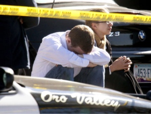 A man sits near the scene of a shooting that involved Rep. Gabrielle Giffords, D-Ariz., on Saturday, Jan. 8, 2011 in Tucson, Ariz. (AP Photo/Arizona Daily Star, Kelly Presnell)