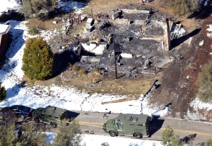 In this aerial photo, law enforcement authorities investigate at a burned-out cabin Wednesday, Feb.13, 2013, where accused quadruple-murder suspect Christopher Dorner was believed to have died after barricading himself inside. (AP Photo/The Sun, John Valenzuela)