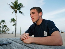 In this Monday, Jan. 10, 2011 photo, soccer player John Rooney sits on the beach in Fort Lauderdale, Fla. talking to the media. The back of Rooney's neck is beet red, which is what happens when an Englishman comes to Florida to escape the shadow of his famous brother, Wayne. A newcomer to the United States, John attended a Major League Soccer combine for the past five days and plans to play in the league this year. (AP Photo/J Pat Carter)