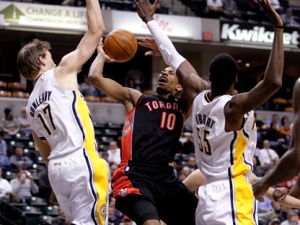 Toronto Raptors guard DeMar DeRozan, center, is fouled as he shoots between Indiana Pacers forward Mike Dunleavy, left, and center Roy Hibbert in the first half of an NBA basketball game in Indianapolis, Monday, Jan. 31, 2011. (AP Photo/Michael Conroy)