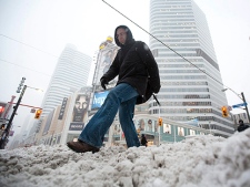 Pedestrians make their way through the snow at Yonge and Dundas Square in downtown Toronto Wednesday, February 2, 2011. (THE CANADIAN PRESS/Darren Calabrese)