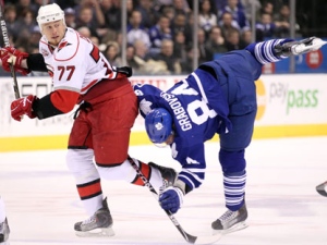 Carolina Hurricanes defenceman Joe Corvo (77) sends Toronto Maple Leafs centre Mikhail Grabovski (84) tumbling with a hit during second period NHL hockey action in Toronto on Thursday February 3, 2011. (THE CANADIAN PRESS/ Frank Gunn)