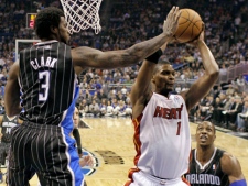 Miami Heat's Chris Bosh, right, grabs a rebound away from Orlando Magic's Earl Clark and Dwight Howard, right, during an NBA game in Orlando, Fla., on Thursday, Feb. 3, 2011. (AP/John Raoux)