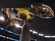 The Vince Lombardi Trophy is lifted in the air after the Green Bay Packers' 31-25 win over the Pittsburgh Steelers in the NFL's Super Bowl XLV on Sunday, Feb. 6, 2011, in Arlington, Texas. (AP Photo/Charlie Krupa)