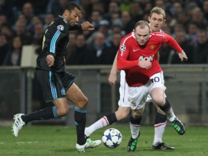 Manchester United's Wayne Rooney, right, challenges for the ball with Marseille midfielder Edouard Cisse during their Champions League soccer match at the Velodrome Stadium in Marseille, France, on Wednesday, Feb. 23, 2011. (AP Photo/Claude Paris)