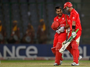 Canadian cricket team captain Ashish Bagai, left, and teammate John Davison walk with smiles on their faces after winning their cricket world cup match against Kenya in New Delhi, India, Monday, March 7, 2011. (AP Photo/Saurabh Das)