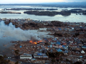 Smoke billows from houses in Natori, northern Japan, after the area was hit by a powerful earthquake and a tsunami on Friday March 11, 2011. The ferocious tsunami spawned by one of the largest earthquakes ever recorded slammed Japan's eastern coast Friday, killing scores of people as it swept away boats, cars and homes while widespread fires burned out of control. (AP Photo/Mainichi Shimbun, Taichi Kaizuka)