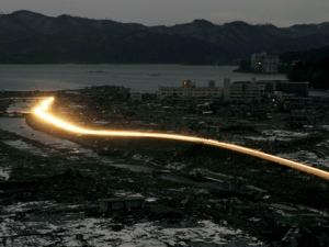 Headlights of vehicles stream along a landscape destroyed in Friday's earthquake and tsunami in Minamisanriku, Japan, on March 17, 2011. (AP Photo/Kyodo News)