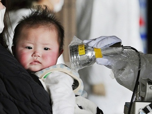 An baby is screened at an evacuation center for leaked radiation from the damaged Fukushima nuclear facilities, at the city of Fukushima, northeastern Japan, on Thursday March 24, 2011. (AP Photo/Kyodo News) 