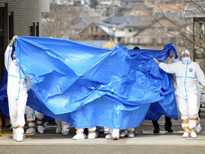 Workers, who stepped into radiation-contaminated water during Thursday's operation at the Fukushima Dai-ichi nuclear plant, are shielded with tarps before receiving decontamination treatment at a hospital in Fukushima, northeastern Japan Friday, March 25, 2011. Later the men were transferred to a radiology medical institute for further treatment. (AP Photo/Kyodo News) 