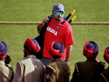 India's Yuvraj Singh poses for a photograph after batting in the nets as Indian police stand guard during a training session in Mohali, India, on Monday, March 28, 2011. India will play Pakistan in the semifinal cricket World Cup match in Mohali on Wednesday, March 30, 2011. (AP Photo)