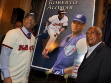 Roberto Alomar, left, newly-elected member of The National Baseball Hall of Fame, poses for photos with his father Sandy Alomar during a news conference in New York, Thursday, Jan. 6, 2011. (AP Photo/Richard Drew)