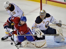 Montreal Canadiens' David Desharnais breaks through Buffalo Sabres goalie Ryan Miller and Paul Gaustad to get to the puck during second period NHL hockey action Tuesday, March 22, 2011 in Montreal. THE CANADIAN PRESS/Paul Chiasson