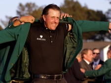 Former Master's champion Angel Cabrera of Argentina, obscured at rear, helping Phil Mickelson put on his Masters jacket after his win at the 2010 Masters golf tournament in Augusta, Ga. (AP Photo/David J. Phillip, File)