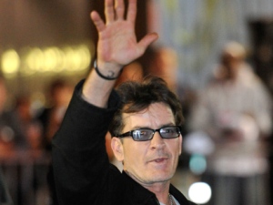 Charlie Sheen waves to fans as he leaves the Chicago Theatre on Sunday, April 3, 2011, in Chicago. Promising "the real story," the 45-year-old former "Two and a Half Men" star continued his month-long, 20-city variety show tour, with Sunday's sold-out show in Chicago. (AP Photo/Brian Kersey)