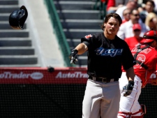 Toronto Blue Jays' Travis Snider tosses his helmet after striking out to end the top of the second inning as Los Angeles Angels catcher Bobby Wilson, right, heads to the dugout during a baseball game in Anaheim, Calif., Sunday, April 10, 2011. (AP Photo/Chris Carlson)