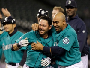 Seattle Mariners' Luis Rodriguez is hugged by Miguel Olivo after Rodriguez hit the game-winning runs in against the Toronto Blue Jays in the ninth inning of a Major League Baseball game Monday, April 11, 2011, in Seattle. The Mariners won 8-7. (AP Photo/Elaine Thompson)