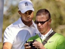 In this Dec. 1, 2010 file photo, Tiger Woods views a video of his tee shot, made by his swing coach Sean Foley, during the Pro-Am round of the Chevron World Challenge golf tournament at Sherwood Country Club in Thousand Oaks, Calif. (AP Photo/Reed Saxon, File)