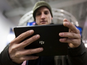 A customer plays with the Blackberry Playbook during the tablet's launch in Toronto Tuesday, April 19, 2011. (THE CANADIAN PRESS/Darren Calabrese)