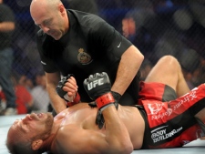 Randy Couture, bottom, attended to by the referee after being knocked out by Lyoto Machida during the light heavyweight bout at UFC 129 in Toronto on Saturday, April 30, 2011. (THE CANADIAN PRESS/Nathan Denette)