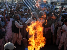 Angry supporters of Pakistani religious party Jamiat Ulema-e-Islam burn representation of the United States during a rally to condemn the killing of Osama bin Laden in Quetta, Pakistan on Monday, May 2, 2011. al-Qaida chief Osama bin Laden was slain in his hideout in Pakistan early Monday in a firefight with U.S. forces, ending a manhunt that spanned a decade. (AP Photo/Arshad Butt)