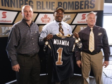 St. Francis Xavier linebacker Henoc Muamba was presented a Winnipeg Blue Bombers jersey by Vice President and General Manager of Football Operations Joe Mack (right) and Head Coach Paul LaPolice (left) after being selected first overall in the 2011 CFL Canadian Draft by the Winnipeg Blue Bombers earlier today, Sunday, May 8, 2011. (The Canadian Press/Canadian Football League)