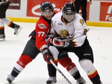 Windsor Spitfires', Scott Timmins, left, reaches for the puck around Owen Sound Attack's Keevin Cutting during third period OHL hockey action on Thursday, Feb. 4, 2010 in Windsor, Ont. THE CANADIAN PRESS/ Greg Plante