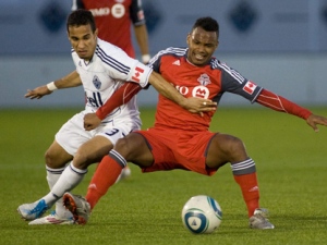 Vancouver Whitecaps' Camilo da Silva Sanvezzo, left, takes down Toronto FC's Julian de Guzman during game 1 Nutrilite Canadian Championship finals soccer action in Vancouver, B.C., on Wednesday May 18, 2011. Toronto are now ahead in the series with an away goal in 1-1 tie against Vancouver. (THE CANADIAN PRESS/Geoff Howe)