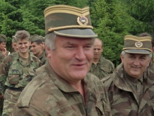 In this June 28, 1996 file photo Bosnian Serb military commander General Ratko Mladic, centre, smiles as he visits troops to mark both the fourth anniversary of the founding of his Bosnian Serb army and St. Vitus' Day, the anniversary of the Serb defeat by the Turks at Kosovo in 1389, near the village of Han Pijesak, some 40 miles east of Sarajevo. Belgrade media reports Thursday, May 26, 2011, that a man suspected to be Europe's most wanted war crimes fugitive Ratko Mladic has been arrested in Serbia. Serbia state TV said a man who identified himself as Milorad Komadic when he was arrested Thursday is the wartime Bosnian Serb army commander. It gave no other details. (AP Photo)