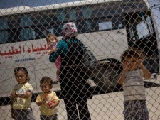 A Palestinian family waits before crossing into Egypt through the Rafah border crossing, southern Gaza Strip, Saturday, May 28, 2011. Egypt officially and fully reopens its passenger crossing with Gaza at the town of Rafah, after a long period of restrictions aimed at isolating the Hamas militant group that rules the Palestinian coastal strip which could ease the isolation of 1.4 million Palestinians there. (AP Photo/Bernat Armangue)