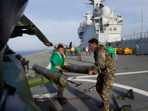 In this photo made available by French Army Saturday June 4, 2011, two mechanics carry munitions to a combat helicopter, on the deck of French navy vessel BPC Tonnerre in the Mediterranean sea. British Apache and French attack helicopters struck targets for the first time in NATO's campaign in Libya, hitting Moammar Gadhafi's troops early Saturday near a key coastal oil town, the alliance said. Hours later, at least eight airstrikes were heard in Tripoli. (AP Photo/Arnaud Roine/ECPAD) 