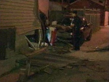 Police inspect the damage at a Harvie Avenue house that was struck by a car Monday, June 6, 2011.
