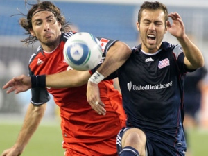 Toronto FC forward Alan Gordon, left, and New England Revolution defender AJ Soares, right, battle for possession of the ball during the first half of an MLS soccer game at Gillette Stadium in Foxborough, Mass., Wednesday, June 15, 2011. (AP Photo/Stew Milne)