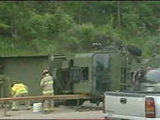 A military vehicle that was towing a similar car flipped over on Highway 400, causing a major closure during evening rush hour on Wednesday, June 22, 2011.