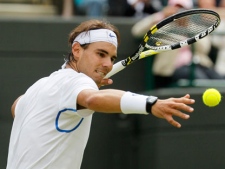 Spain's Rafael Nadal hits a ball into the crowd after defeating Luxembourg's Gilles Muller in their match at the All England Lawn Tennis Championships at Wimbledon, Saturday, June 25, 2011. (AP Photo/Alastair Grant)