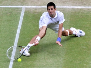 Serbia's Novak Djokovic reaches for a shot during his men's semifinal match against France's Jo-Wilfried Tsonga at the All England Lawn Tennis Championships at Wimbledon, Friday, July 1, 2011. (AP Photo/Carl De Souza, Pool)