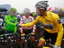 Thor Hushovd of Norway, wearing the overall leader's yellow jersey, right, shakes hands with Jose Joaquin Rojas of Spain, wearing the best sprinter's green jersey, left, next to Philippe Gilbert of Belgium, wearing the best climber's dotted jersey, prior to the start of the fourth stage of the Tour de France cycling race over 172.5 kilometers (107.2 miles) starting in Lorient and finishing in Le Mur de Bretagne, Brittany, western France, Tuesday July 5, 2011. (AP Photo/Christophe Ena)
