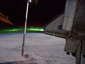 This panoramic view provided by NASA was photographed from the International Space Station, looking past the docked space shuttle Atlantis' cargo bay and part of the station including a solar array panel toward Earth, was taken on July 14, 2011 as the joint complex passed over the southern hemisphere. Aurora Australis or the Southern Lights can be seen on Earth's horizon and a number of stars are visible also. (AP Photo/NASA)