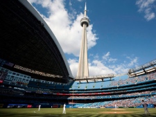 The CN Tower looms over the Toronto Blue Jays and Detroit Tigers as the Rogers Centre's roof is open for the first time in the 2011 MLB baseball season in Toronto Saturday, May 7, 2011. (THE CANADIAN PRESS/Darren Calabrese)