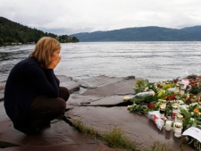 A woman mourns in Sundvollen, close to Utoya island, where gunman Anders Behring Breivik killed at least 68 people, near Oslo, Norway, Tuesday, July 26, 2011. Norwegian police on Tuesday began releasing the names of those killed in last week's bomb blast and massacre at a youth camp, an announcement likely to bring new collective grief to an already reeling nation. (AP Photo/Ferdinand Ostrop)