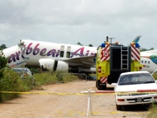 The broken fuselage of a Caribbean Airlines' Boeing 737-800 is seen after it crashed at the end of the runway at Cheddi Jagan International Airport in Timehri, Guyana, Saturday, July 30, 2011. The Caribbean Airlines flight 523 from New York touched down on the rainy runway, slid through a chain-link fence and broke apart just short of a ravine but there were no immediate reports of death among the 163 people aboard, despite several dozen of injuries. (AP Photo/Jules Gibson)