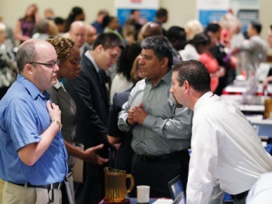 In this Aug. 4, 2011 photo, job seeker Manfred A. Lynch, left, speaks with a recruiter at a job fair in Arlington, Va. The Labor Department announced Friday, Aug. 5, 2011 that hiring picked up slightly in July and the unemployment rate dipped to 9.1 percent as employers added 117,000 jobs. (AP Photo/Jose Luis Magana)