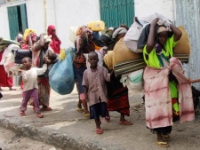 Somalis carry their belongings from southern Somalia as they arrive in Mogadishu, Somalia, Friday, Aug. 5, 2011. The United Nations says famine will probably spread to all of southern Somalia within a month and force tens of thousands more people to flee into the capital of Mogadishu. (AP Photo/Farah Abdi Warsameh)