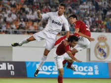 Real Madrid's Cristiano Ronaldo, left, reacts after shooting a header against China's club team Guangzhou Evergrande's Feng Xiaoting, center, and Peng Shaoxiong during a friendly match in Guangzhou, southern China's Guangdong province Wednesday, Aug. 3, 2011. (AP Photo/Vincent Yu)