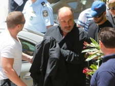 Achilleas Beos owner of the Greek Superleague soccer team Olympiakos Volos, escorted by police, arrives at a court in Athens, Thursday, June 23, 2011. Police in Greece say 10 people have been arrested as part of a match-fixing probe based on irregular betting patterns identified by European football's ruling body UEFA. (AP Photo/Thanassis Stavrakis)